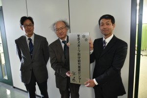 看板を掲げる髙橋学長と鈴木センター長